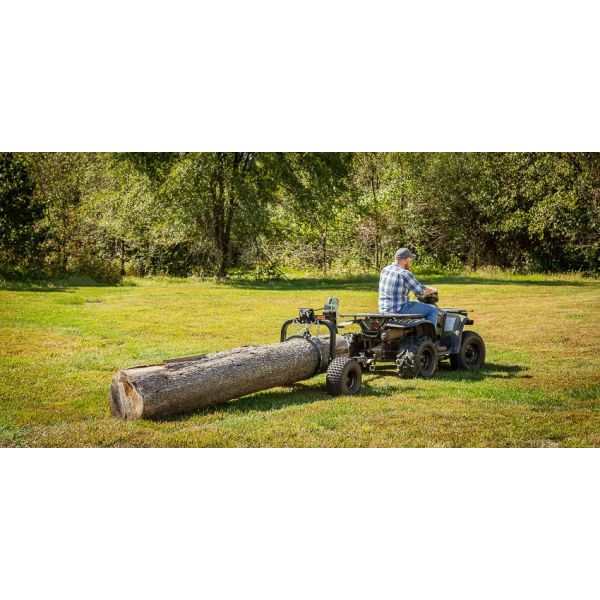 ATV Log Skidder hauling a large log across grassy terrain.