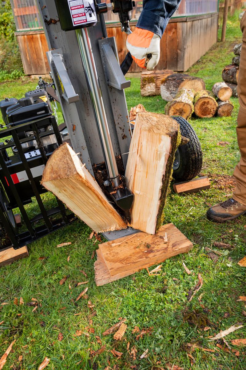 Oregon 30-Ton Gas Log Splitter in action, splitting a large log outdoors with powerful hydraulic force.