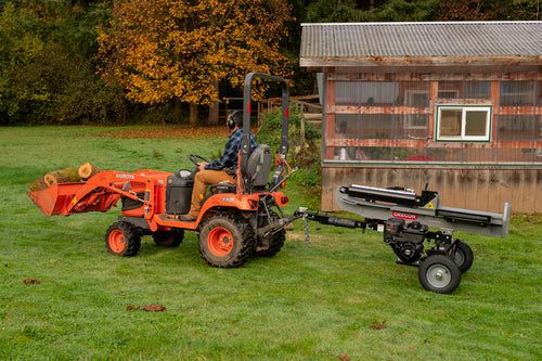 Oregon 35-Ton Gas Log Splitter attached to a tractor in a grassy yard, showcasing its heavy-duty design and efficiency for tough wood splitting tasks.