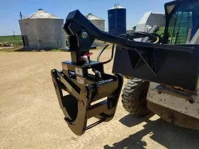 Skid Steer Grapple attachment on loader in farm setting.